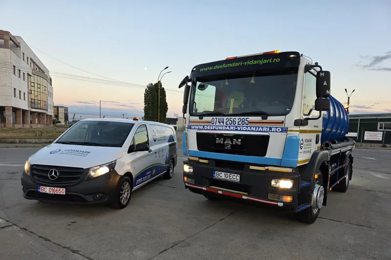 Autoutilitara și autospeciala văzute din față, cu farurile aprinse